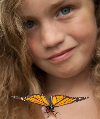 A young girl presents her Monarch Butterfly during a butterfly release in Minnesota.